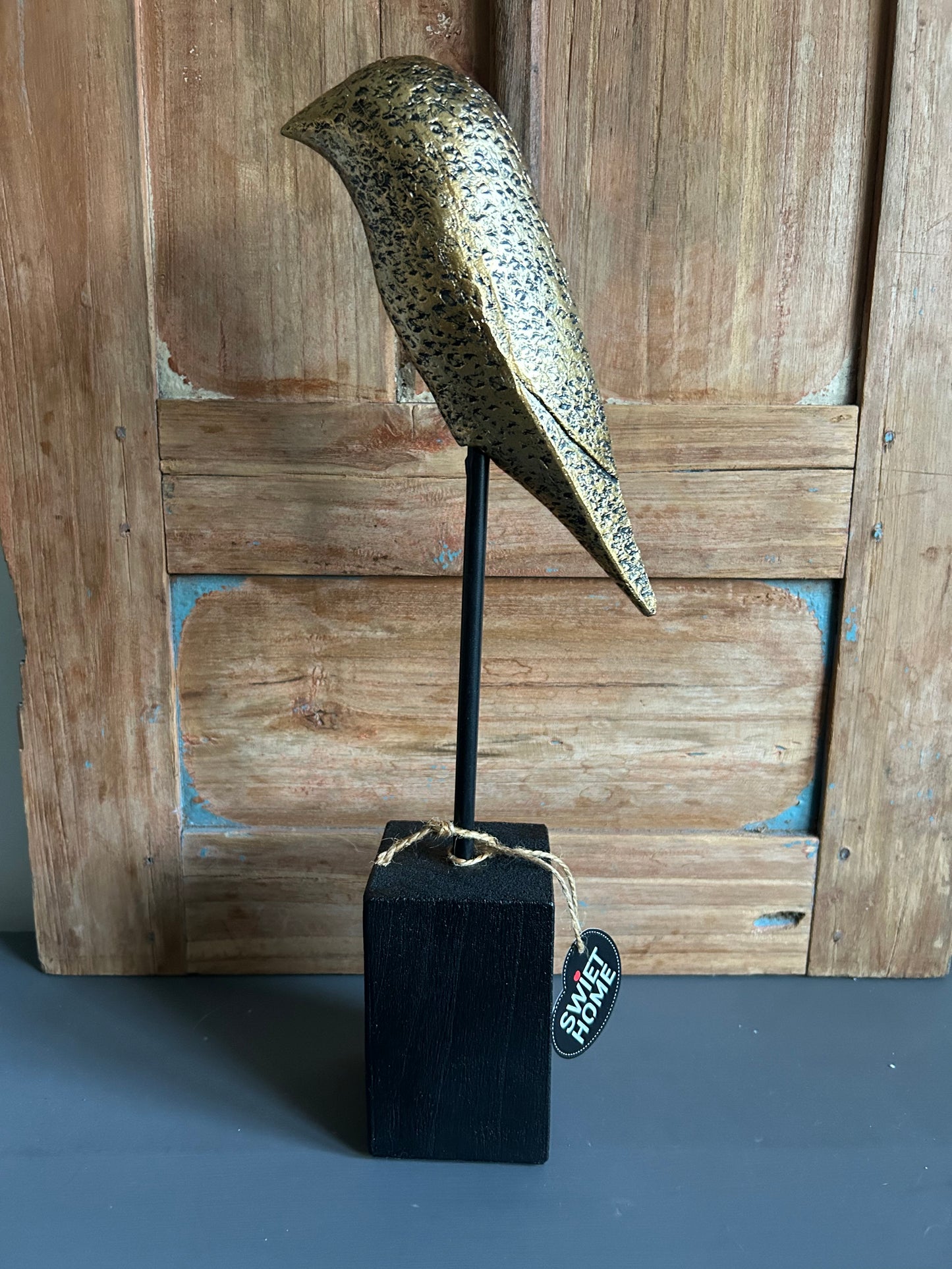 goudkleurige vogel op voet maat L