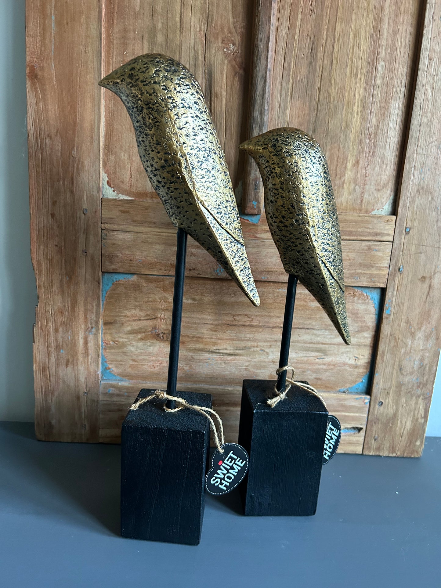 goudkleurige vogel op voet maat L