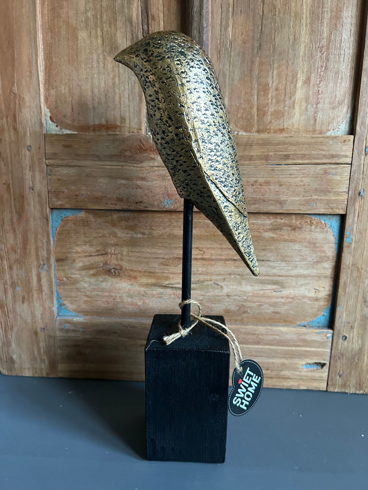 goudkleurige vogel op voet maat S